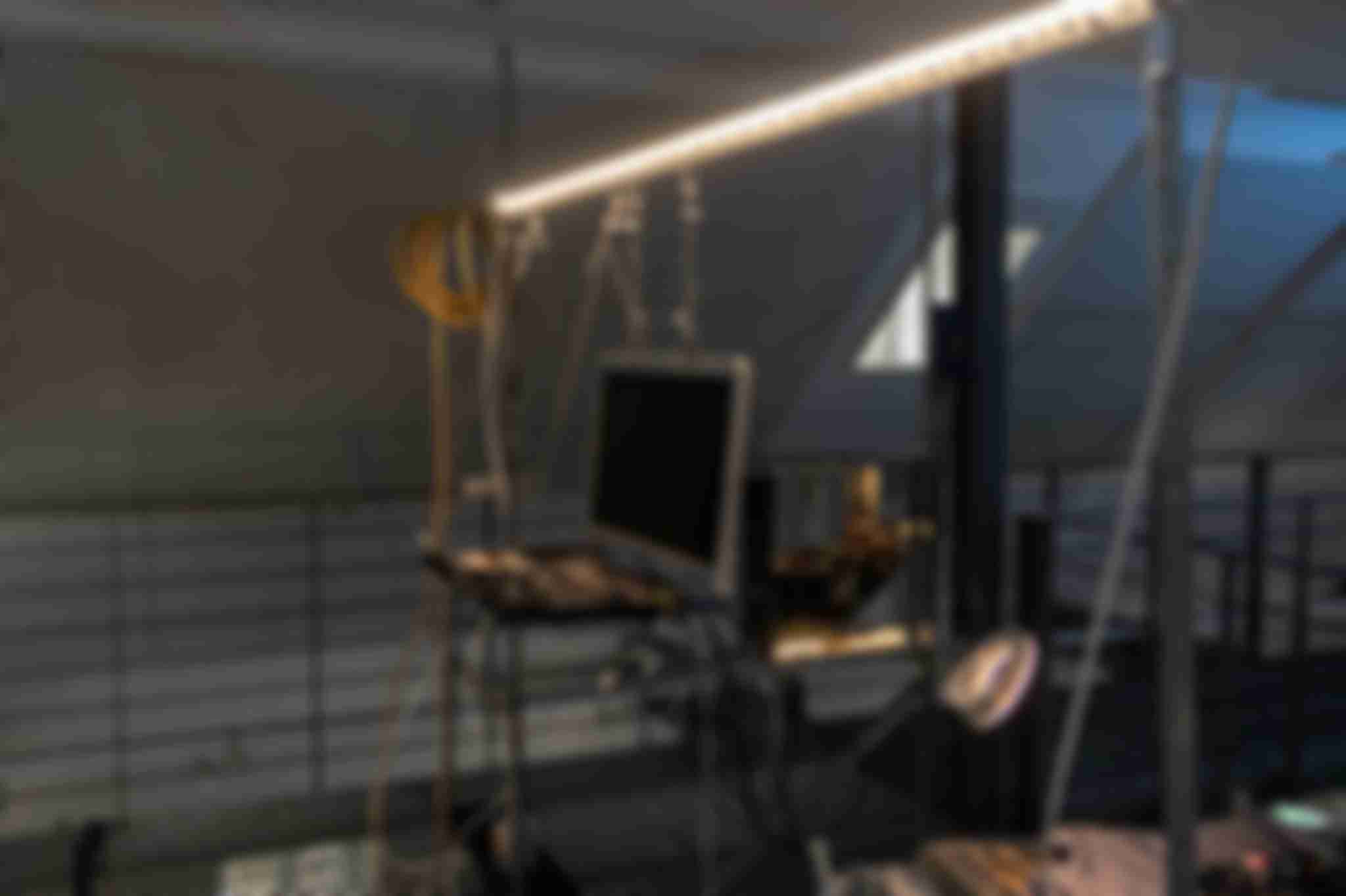 A side view of the /sys/net/visible installation which shows a opened up laptop hanging from aluminium profiles. In the background a desktop PC is visible.