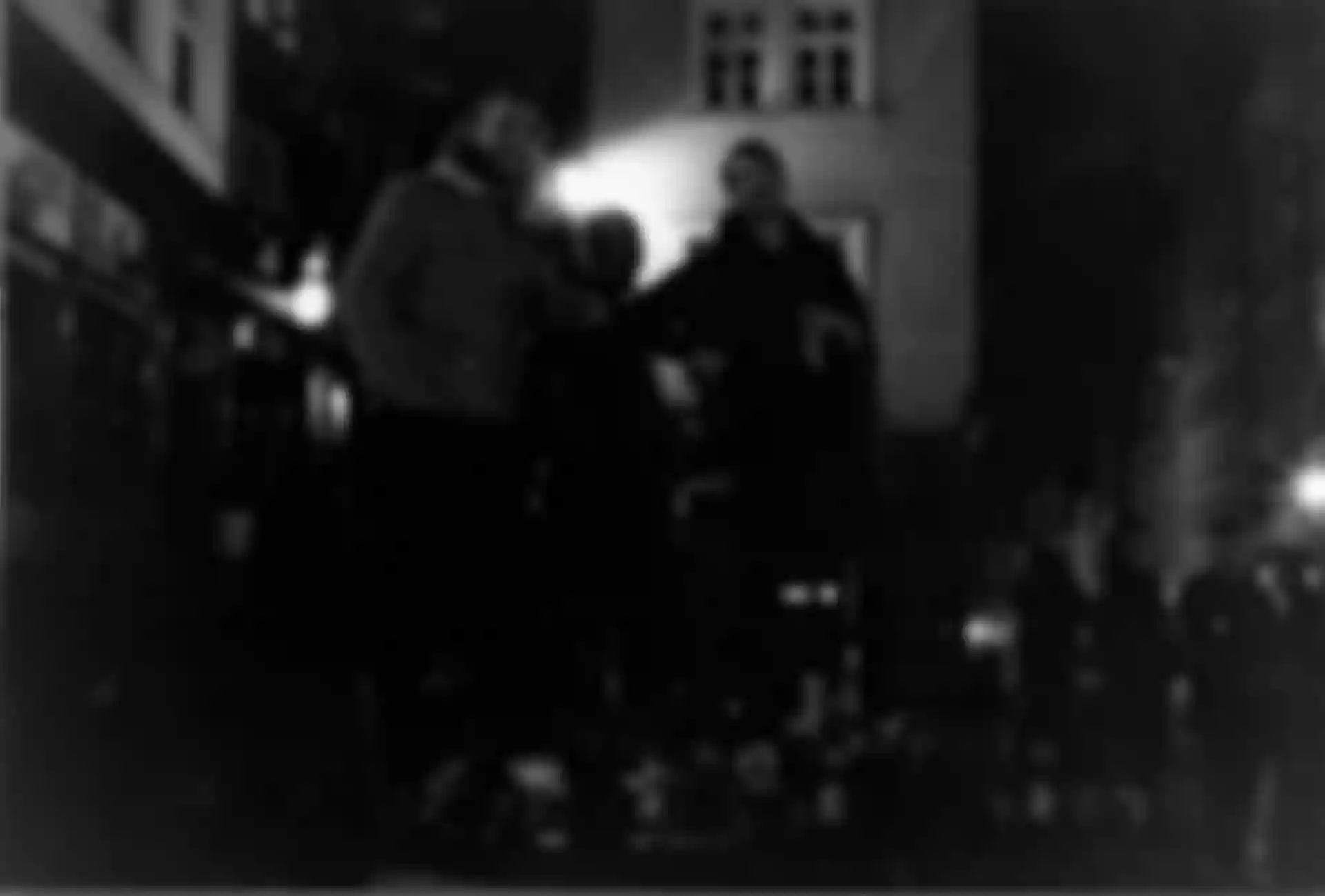 Zwei Männer posieren im Dunkeln mit einer Statue.