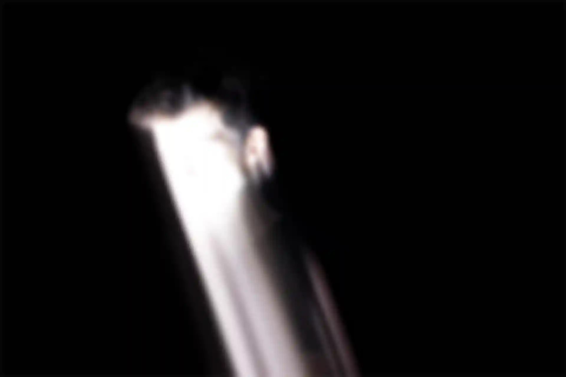 Ein Mann mit einem überbelichteten Gesicht bewegt sich diagonal in die rechte untere Ecke.